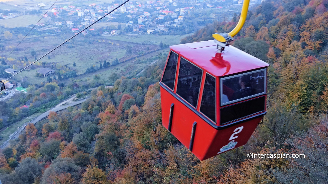 Photo of a gondola climbing over the mountain forest