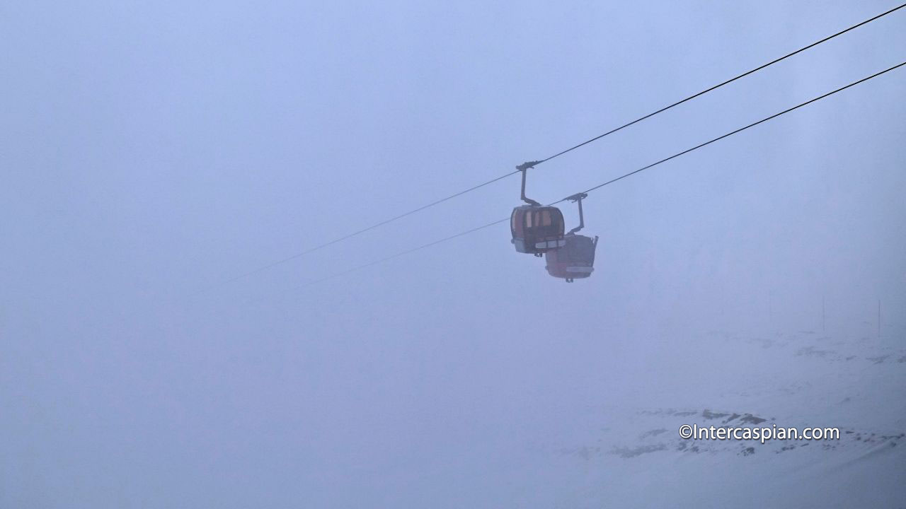 Photo de deux cabines de la télécabine du Tochal dans les nuages, Téhéran